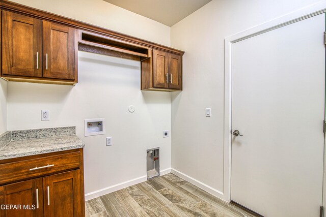 washroom featuring hookup for an electric dryer, gas dryer hookup, light hardwood / wood-style flooring, cabinets, and hookup for a washing machine