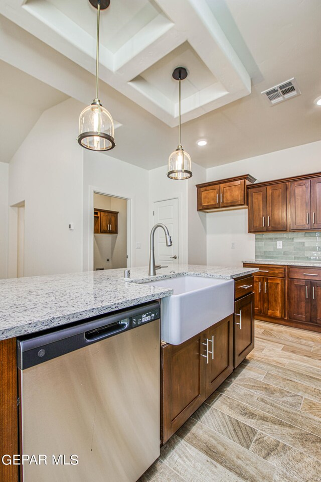 kitchen featuring stainless steel dishwasher, light stone countertops, light hardwood / wood-style flooring, and tasteful backsplash