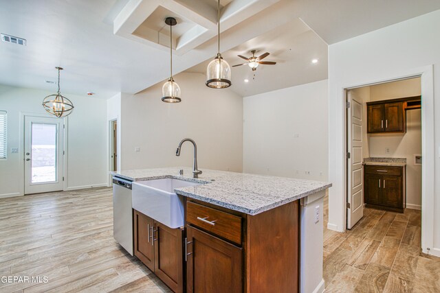 kitchen with pendant lighting, dishwasher, sink, ceiling fan with notable chandelier, and a center island with sink