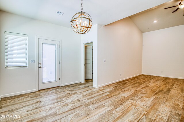 interior space with ceiling fan with notable chandelier, light wood-type flooring, and vaulted ceiling