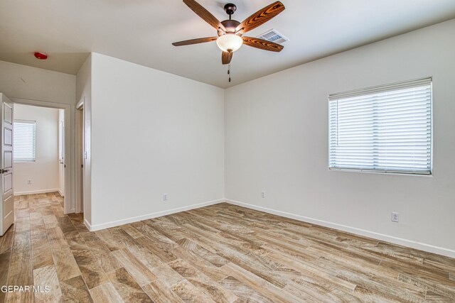 empty room with light wood-type flooring, ceiling fan, and plenty of natural light