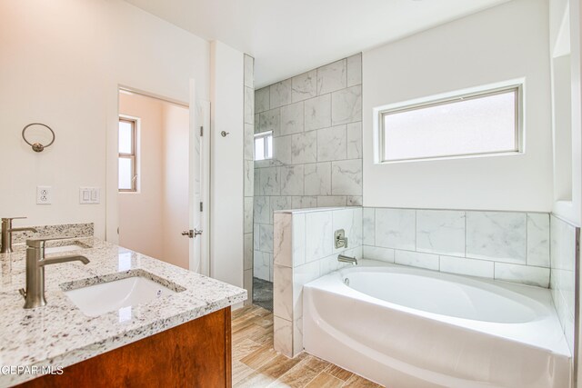 bathroom featuring vanity, plus walk in shower, and hardwood / wood-style floors