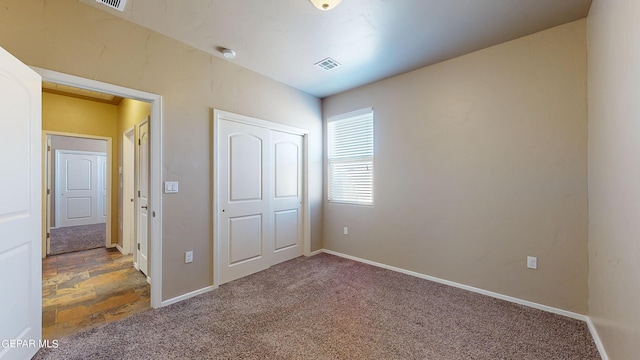 unfurnished bedroom with a closet and carpet