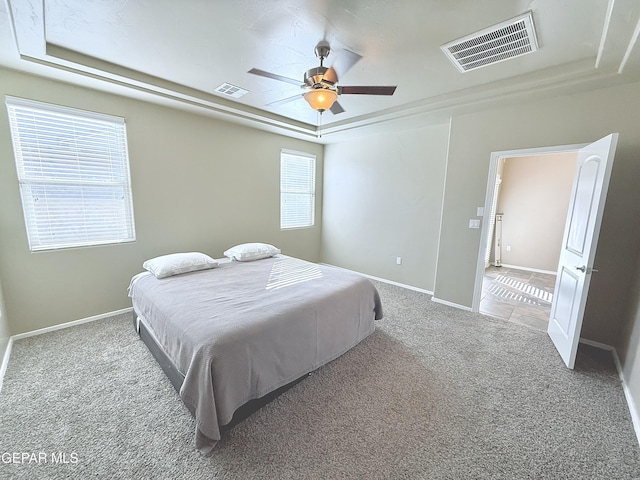 bedroom featuring a tray ceiling, ceiling fan, and carpet flooring