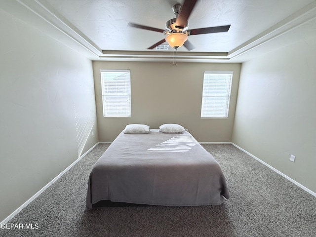 bedroom with carpet, ceiling fan, and a tray ceiling