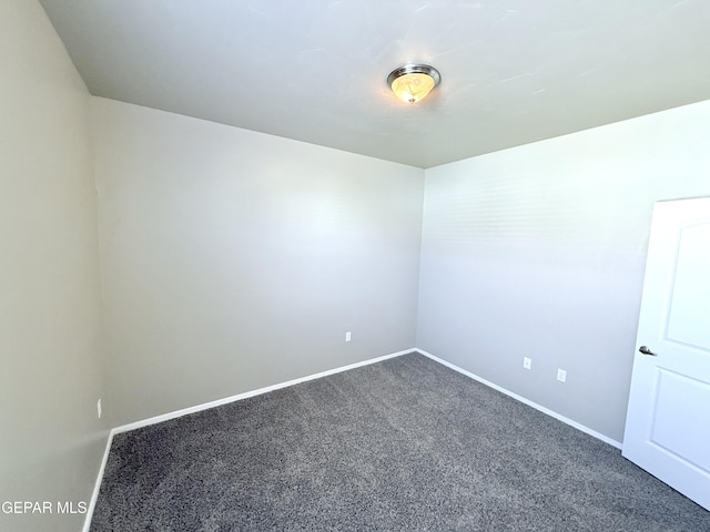 unfurnished room with dark carpet