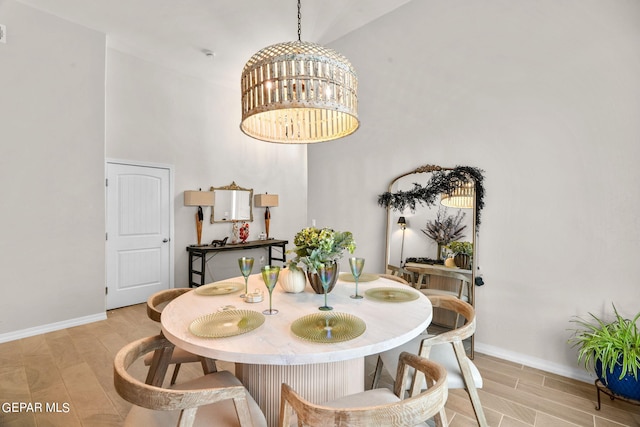 dining space with light hardwood / wood-style floors, high vaulted ceiling, and a notable chandelier