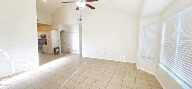 tiled empty room featuring ceiling fan and high vaulted ceiling