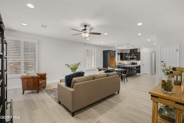 living room with ceiling fan and light hardwood / wood-style floors