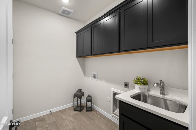 clothes washing area featuring cabinets, hookup for an electric dryer, washer hookup, sink, and hookup for a gas dryer