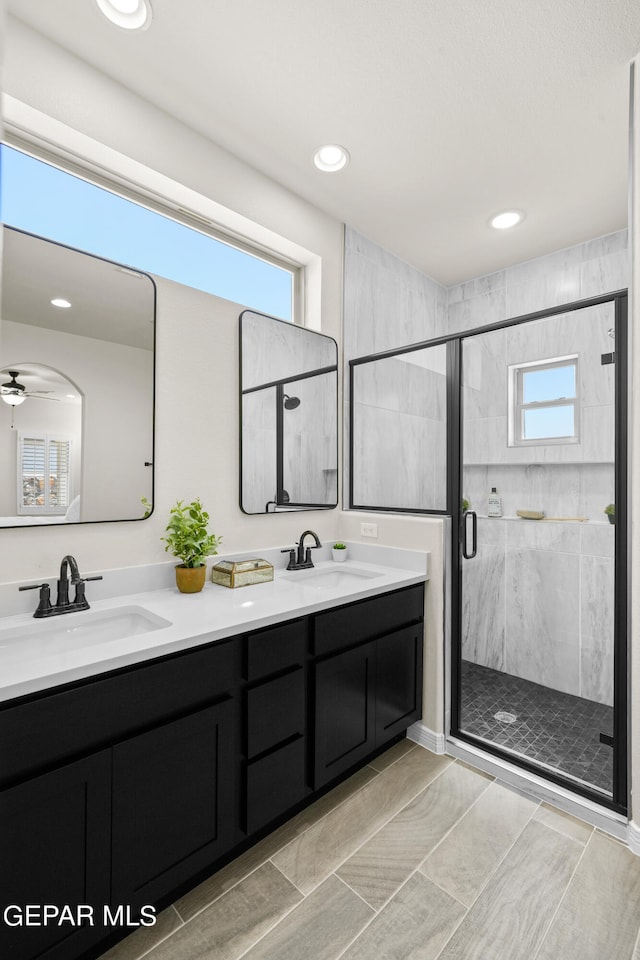 bathroom featuring vanity, ceiling fan, and an enclosed shower