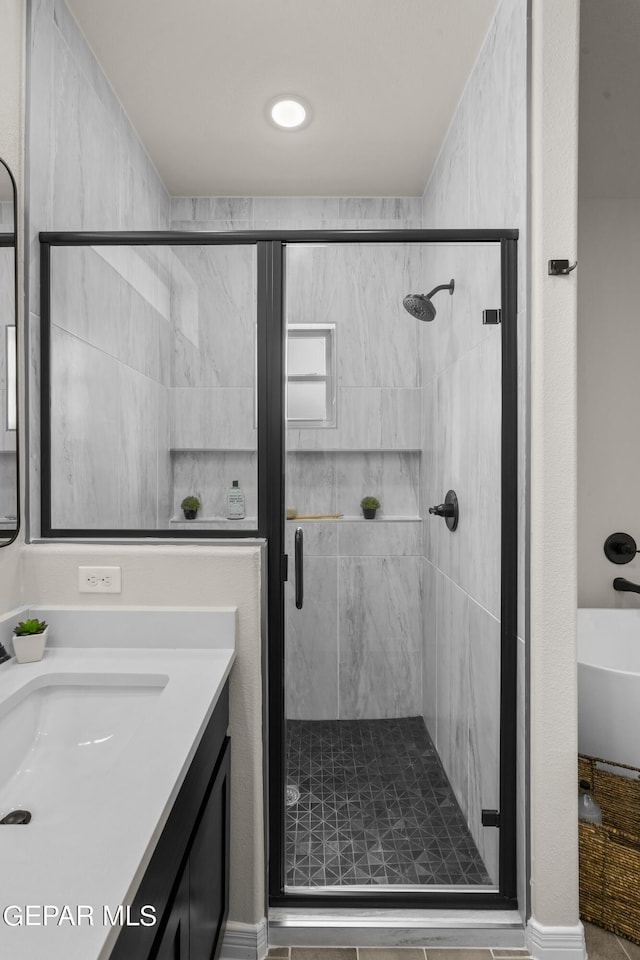 bathroom with walk in shower and vanity