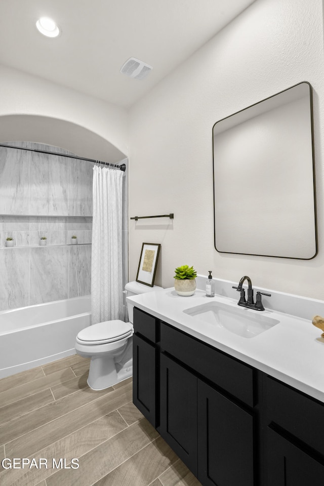 full bathroom with shower / tub combo with curtain, vanity, and toilet