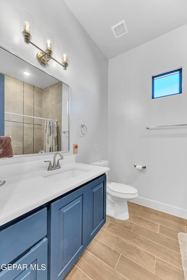 bathroom featuring curtained shower, vanity, and toilet