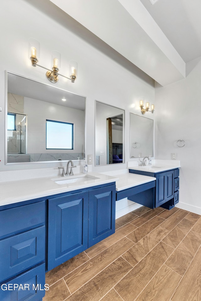 bathroom with a shower with shower door and vanity