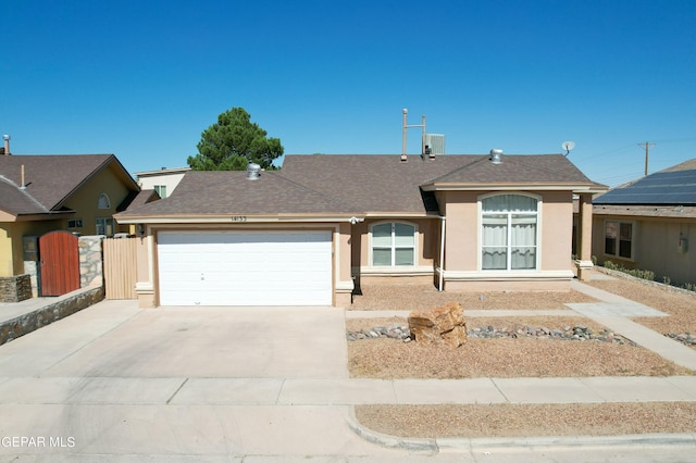 ranch-style house with a garage and central AC unit