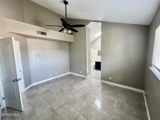 empty room with ceiling fan, a textured ceiling, and lofted ceiling