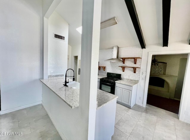 kitchen featuring wall chimney exhaust hood, gas stove, sink, kitchen peninsula, and light tile patterned floors