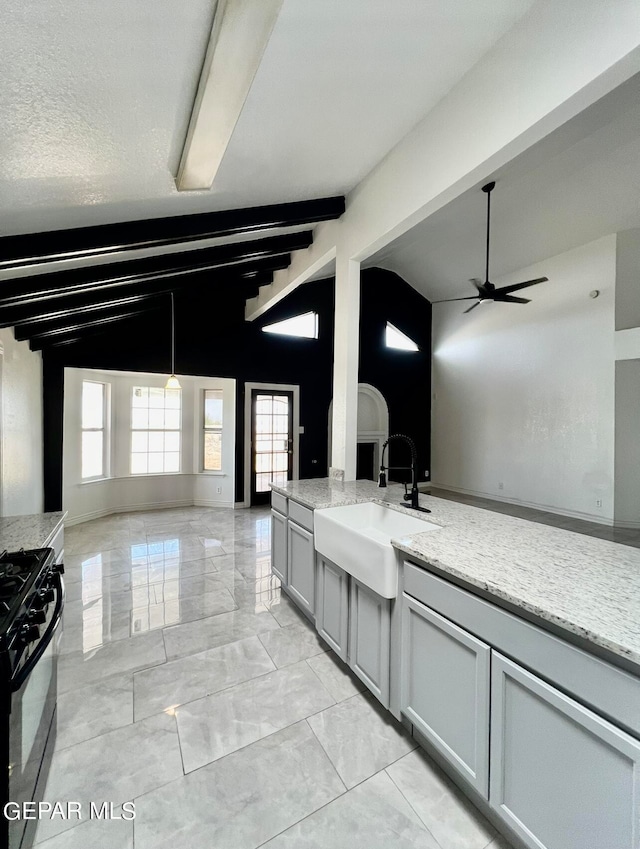 kitchen featuring light stone counters, sink, black range with gas cooktop, a textured ceiling, and lofted ceiling with beams