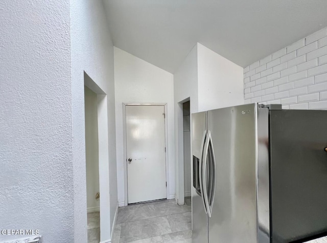 kitchen with lofted ceiling and stainless steel fridge