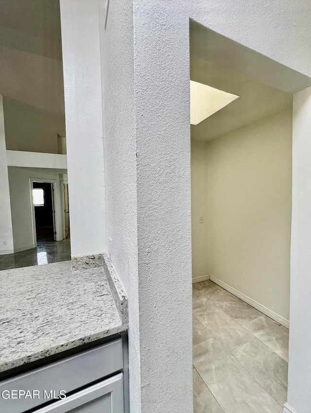 interior space with a textured ceiling and light stone countertops