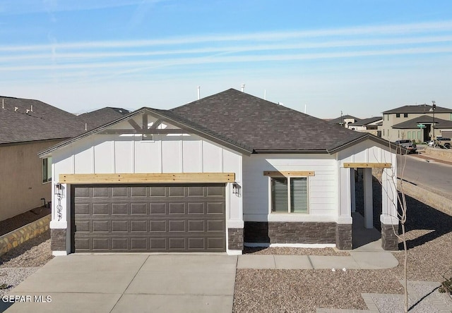 view of front facade with driveway, a garage, board and batten siding, and roof with shingles