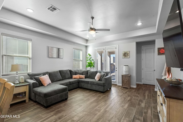 living room featuring ceiling fan and dark hardwood / wood-style floors