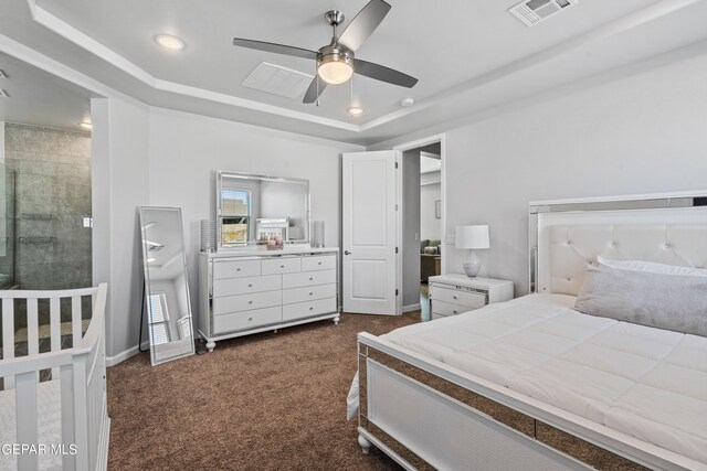 carpeted bedroom with a raised ceiling and ceiling fan