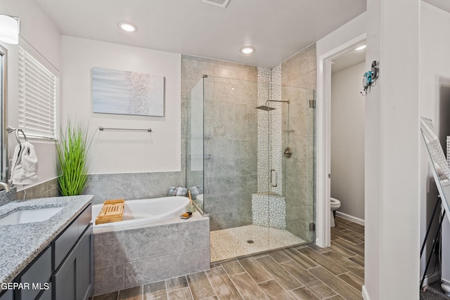 full bathroom featuring independent shower and bath, vanity, and toilet