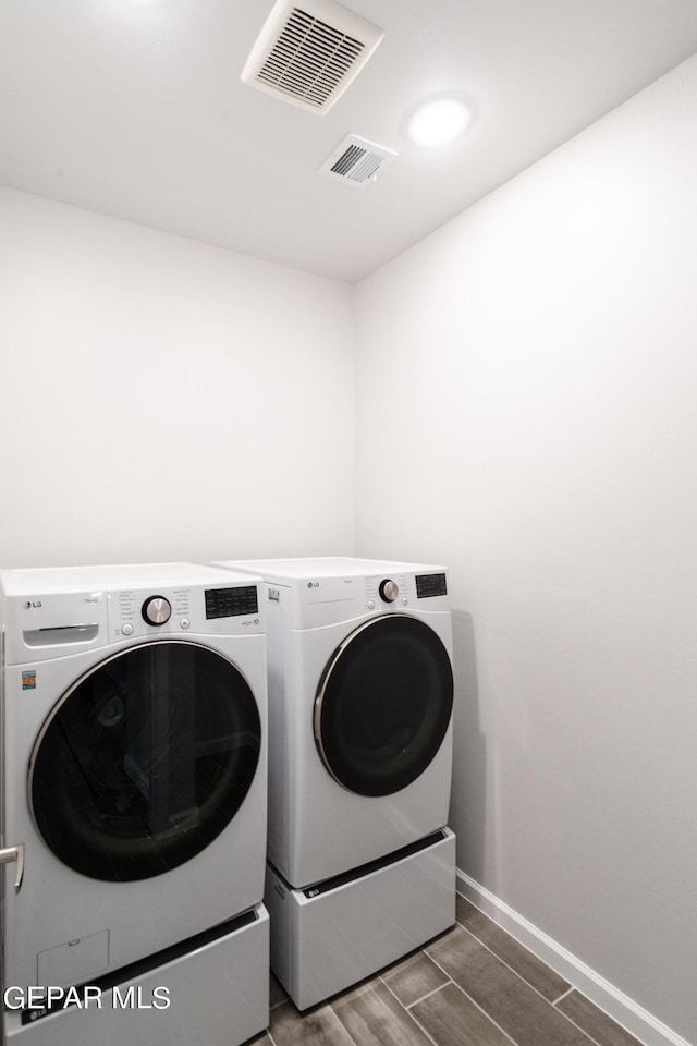 laundry area featuring wood-type flooring and washer and clothes dryer