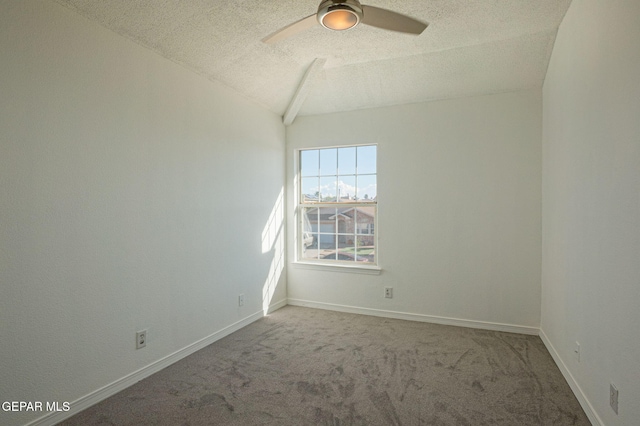 carpeted spare room featuring vaulted ceiling, a textured ceiling, and ceiling fan