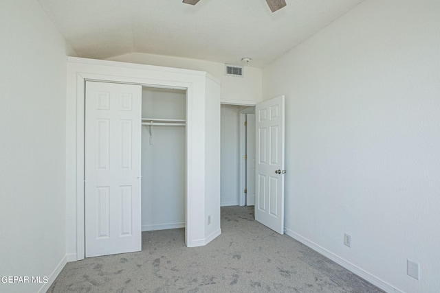 unfurnished bedroom with light carpet, a closet, and vaulted ceiling