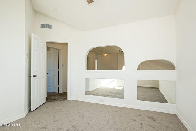 carpeted empty room with lofted ceiling