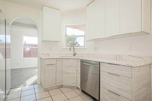 kitchen featuring light stone countertops, white cabinets, a healthy amount of sunlight, and stainless steel dishwasher