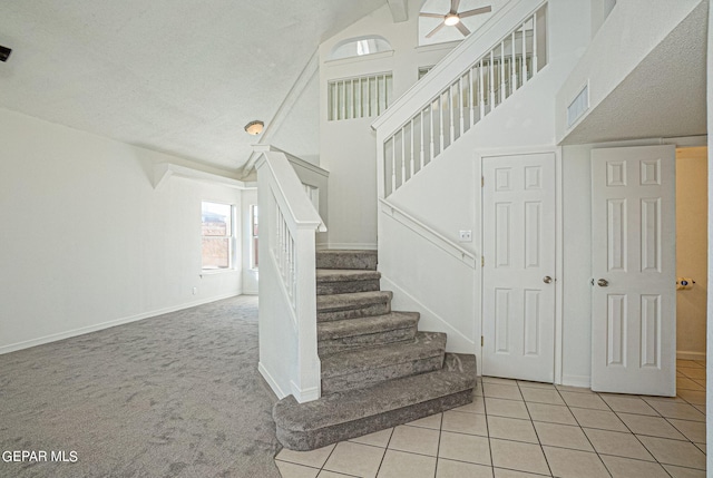 stairway with tile patterned flooring, a textured ceiling, beamed ceiling, high vaulted ceiling, and ceiling fan