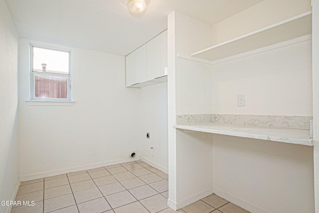 washroom with light tile patterned flooring, hookup for an electric dryer, and cabinets