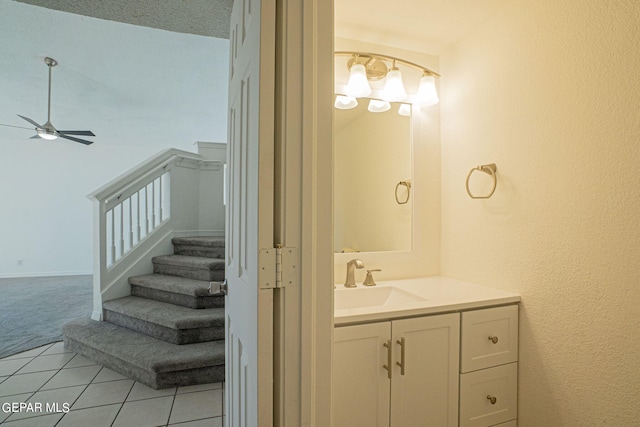 bathroom with ceiling fan, vanity, a textured ceiling, and tile patterned floors