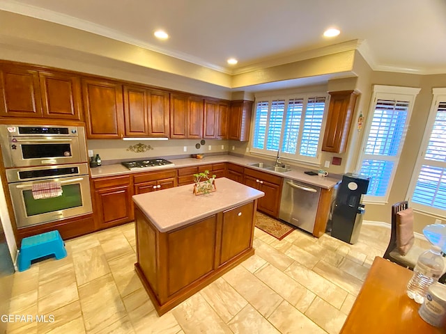 kitchen with stainless steel appliances, ornamental molding, a kitchen island, and sink