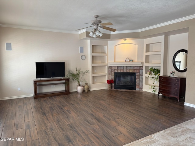 living room featuring built in shelves, a stone fireplace, dark wood-type flooring, and a textured ceiling