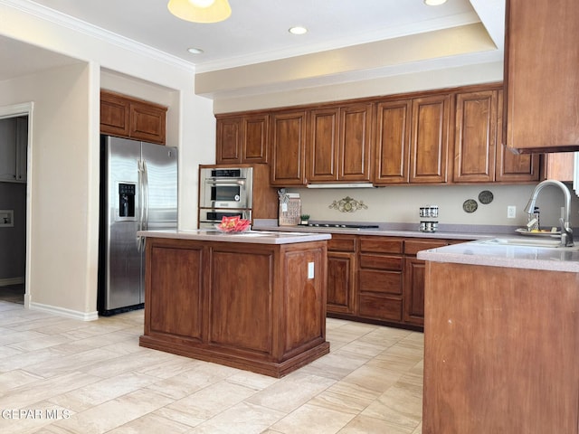 6276 Los Bancos Dr, El Paso, TX 79912 - kitchen with appliances with stainless steel finishes, light countertops, a center island, brown cabinetry, and crown molding