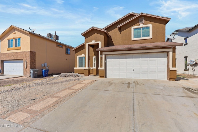 traditional-style house with a garage, stucco siding, and concrete driveway