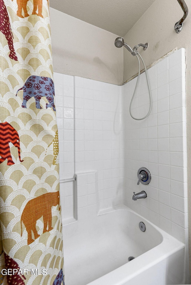 bathroom with a textured ceiling and shower / tub combo