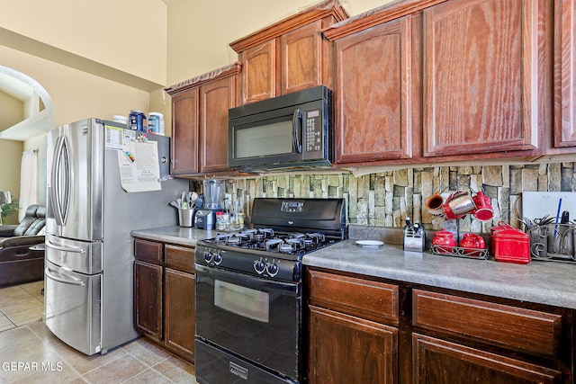 kitchen featuring light tile patterned flooring, backsplash, black appliances, and light countertops