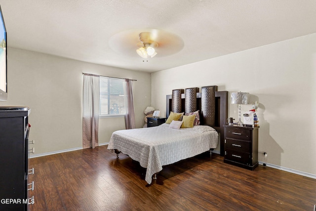 bedroom featuring baseboards, a ceiling fan, and dark wood-style flooring