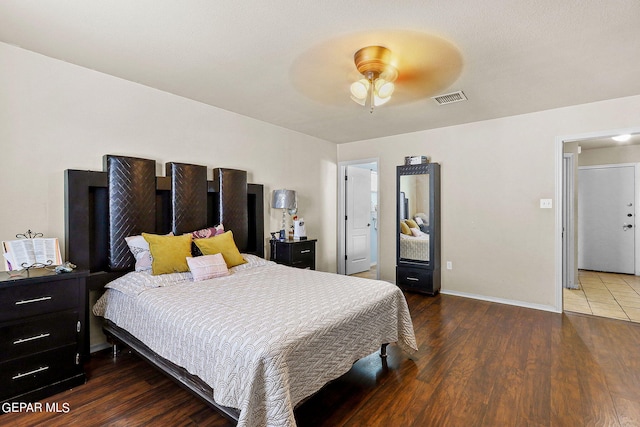 bedroom with a ceiling fan, baseboards, visible vents, and wood finished floors