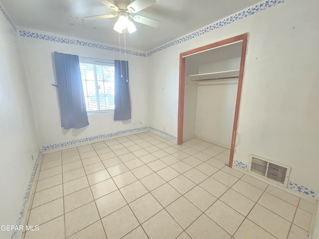 unfurnished bedroom featuring light tile patterned floors, ceiling fan, and a closet