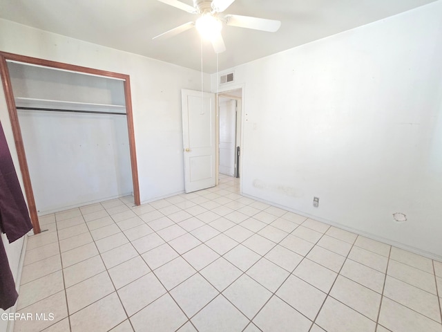 unfurnished bedroom with light tile patterned floors, ceiling fan, and a closet