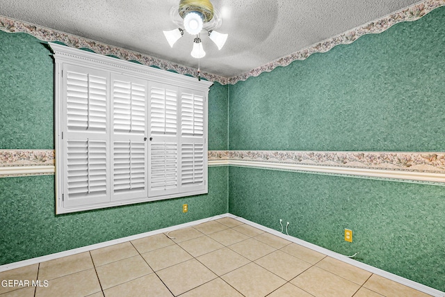 tiled empty room featuring ceiling fan and a textured ceiling