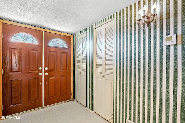 foyer featuring light tile patterned floors and a textured ceiling