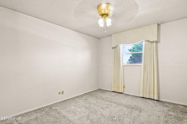 carpeted spare room with ceiling fan and a textured ceiling